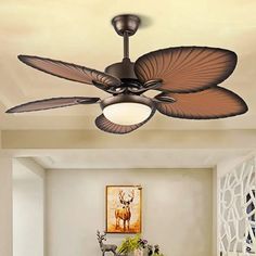 a ceiling fan in a living room with an animal painting on the wall behind it