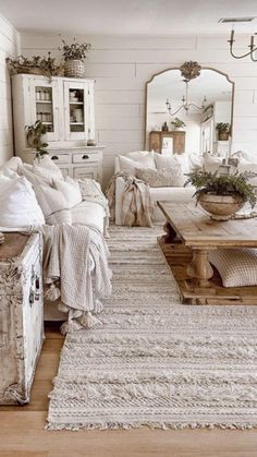 a living room filled with lots of furniture and pillows on top of a wooden floor