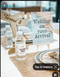 the table is set up with water bottles and place cards for guests to take pictures