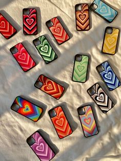 many cell phones with hearts painted on them sitting on a white sheet in the sun