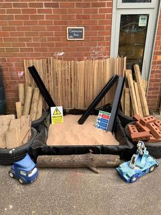 a pile of wood sitting on the side of a road next to a brick building