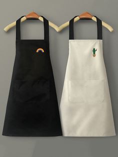 two black and white aprons with cactus embroidered on the front one has a rainbow