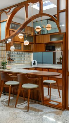 an open kitchen with wooden cabinets and marble counter tops, along with two chairs at the table