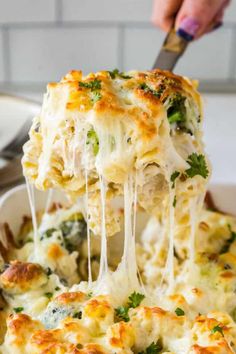 a spoonful of cheesy broccoli casserole being lifted from a dish