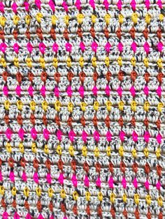 close up view of the crochet stitchs on an afghan blanket with pink, yellow and red accents