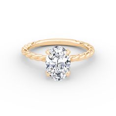 a yellow gold engagement ring with an oval cut diamond in the center and twisted band