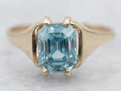 This yellow gold ring is like sunshine on your finger! With its shimmering, emerald cut blue zircon, it's sure to put a sparkle in your eye. So check that box off your wishlist and grab this gold ring before it's too late! *Please note, there are chips on the stone and the piece has been priced accordingly. Metal: 14K Yellow Gold Gem: Blue Zircon 1.93 Carats Gem Measurements: 5.3 x 7.0 mm, Emerald Cut Ring Size: 5 Marks: "VI 14K" Stamped on the inside band SKU #: A32364 Each piece has been ident Modern Blue Baguette Cut Emerald Ring, Classic Blue Radiant Cut Emerald Ring, Blue Solitaire Emerald Ring In Classic Style, Blue Radiant-cut Emerald Ring In Fine Jewelry Style, Blue Radiant Cut Emerald Ring In Fine Jewelry, Blue Solitaire Emerald Ring Classic Style, Blue Emerald Cut Ring For Birthstone, Blue Emerald Cut Ring, Birthstone, Blue Radiant Cut Emerald Ring Fine Jewelry