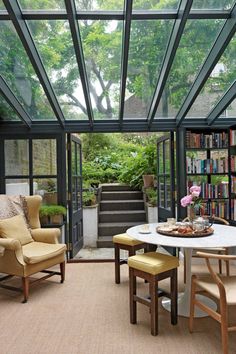 a living room filled with lots of furniture and bookshelves next to a staircase