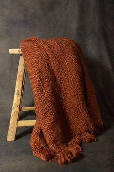 an orange blanket sitting on top of a wooden chair