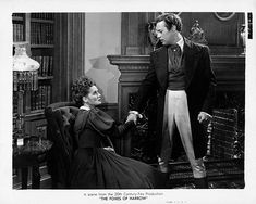 an old photo of a man and woman sitting in chairs with one holding the other's hand