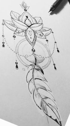 a drawing of a feather with beads on it and a pen next to it that is resting on top of a piece of paper