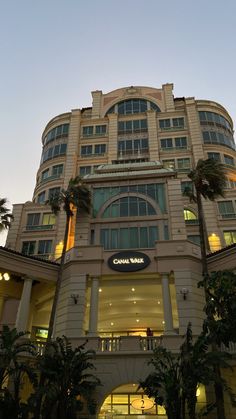 a large building with palm trees in front of it