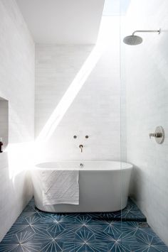 a white bath tub sitting in a bathroom next to a window