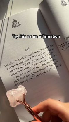 someone holding a pair of scissors in front of an open book with the words try this as an affirmation