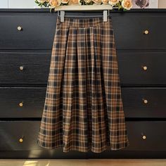 Pleated plaid midi skirt in cozy colors to go with your autumnal fits. Features an elastic waist back. Lined. One Size: 26"-36" waist, 31" length Cozy Colors, Plaid Midi Skirt, Shoe Gifts, Overall Dress, Sweater Blouse, Cardigan Jacket, Autumn Summer, Jeans Pants, Sweaters & Cardigans