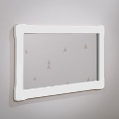 a mirror mounted to the wall with small triangles on it's face and bottom edge