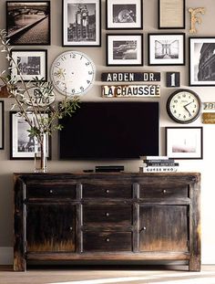 a living room with many pictures on the wall and a large tv mounted to it's side