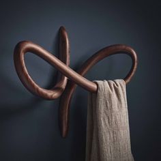 a wooden object hanging on the wall next to a towel rack with two large hooks