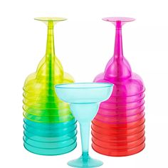 three different colored vases sitting next to each other on a white background, one with a wine glass in the middle