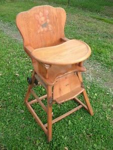 an old wooden high chair sitting in the grass