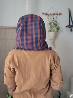 a person wearing a hoodie standing in front of a wall