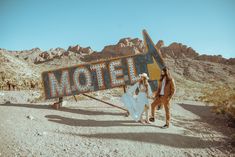 two people standing in front of a motel sign