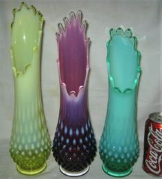 three different colored vases sitting next to each other