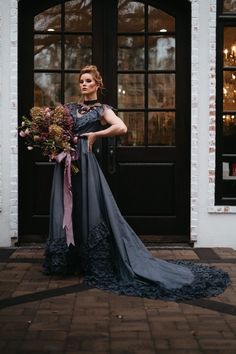 a woman standing in front of a door holding a bouquet