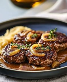 some meatballs with onions and gravy on a plate