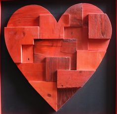 a heart shaped wooden piece in a red frame