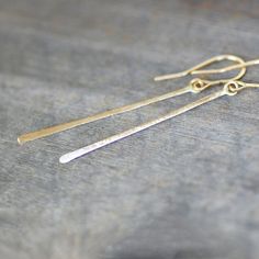 "Long skinny gold earrings. A thin bar of rich gold hammered gradually wider toward the end. Hangs like a long golden thread from handmade paddle end ear wires that mimic the shape of the earrings for a sleek and modern look. Length - About 2 1/4\"\"L Pictured with a brushed satin finish. Also available in rose gold here: https://www.etsy.com/listing/215182350/rose-gold-thread-earrings-long-gold?ref=shop_home_active_1 Made to order. Please see announcement on my shops main page for current produ Gold Thread Earrings, Golden Moments, Silver Flower Ring, Golden Thread, Dangle Earrings Gold, Gold Dangle Earrings, Thread Earrings, Gold Thread, Wedding Jewelry Earrings