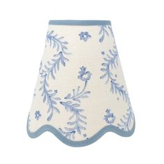 a blue and white lamp shade with flowers on it's side, against a white background