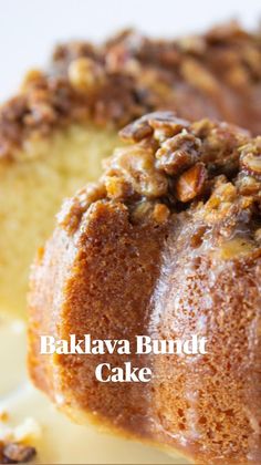 a bundt cake with walnuts on top is sitting on a white plate and ready to be eaten