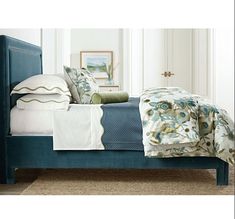 a blue bed with white sheets and pillows