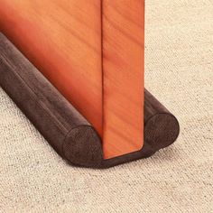 the corner of a bed with a wooden headboard and foot board on carpeted floor