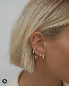 a woman with blonde hair wearing gold earrings