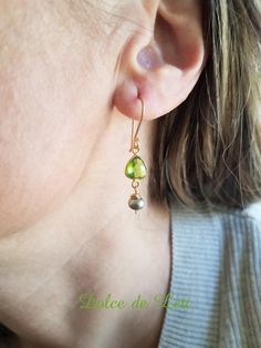 >> These earrings feature a peridot quartz paired with a gray freshwater pearl. >> Wire wrapped by hand with gold filled wire and finished with my signature gold fill French ear wires. >> Earrings include a pair of clear rubber backs (not shown on pics) optional to wear. >> LENGTH: From top of ear wire to bottom of drop measures approx. 1- 5/8" (40 mm) long.  >> The peridot quartz link measures 8 mm wide and the pearl measures 5 mm wide. >> Lightweight earrings. >> Great birthday gift for women, Mother's day gift, or Christmas gift.  >> Peridot is August birthstone. Pearl is June birthstone.    >>You will receive the exact item shown in this listing. >>Hand made at my home studio in Colorado Springs, Colorado. Snow, rain or shine! >>PERSONALIZED NOTE >>If you are buying a gift for someone Green Dangle Earrings, Snow Rain, Artisan Earrings, August Birthstone, Earrings Green, Gold Gift, Earrings In Gold, June Birthstone, Lightweight Earrings