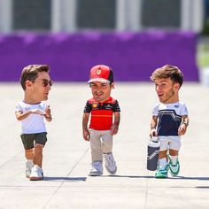 three young boys are walking down the sidewalk