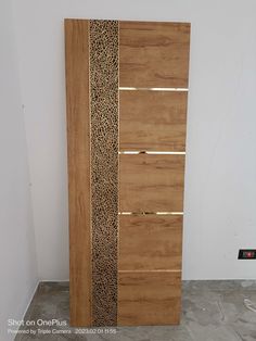 a tall wooden cabinet sitting on top of a cement floor next to a white wall