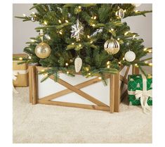 a small christmas tree in a wooden box with lights on it and presents under the tree