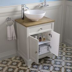 a white sink sitting under a bathroom mirror next to a counter top with a bowl on it