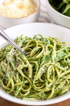 a white bowl filled with pasta and pesto sauce