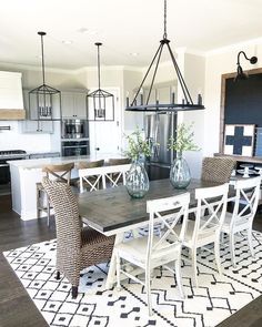 the dining room table is set with white chairs