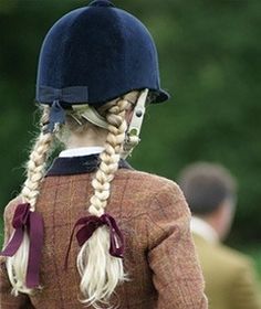 a woman with long blonde hair wearing a blue hat and braids on her head