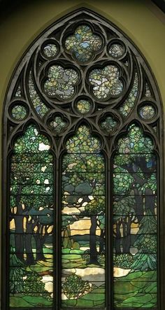 a stained glass window with trees in the background