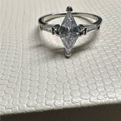 a white diamond ring sitting on top of a table