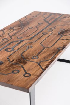 a wooden table with metal legs and designs on it