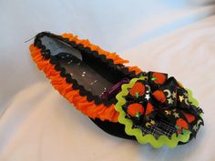 a pair of black and orange shoes sitting on top of a bed