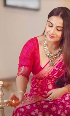 a woman in a pink sari sitting down