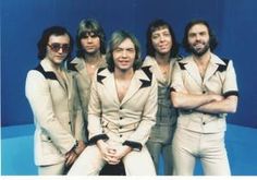 the bee gees posing for a photo in front of a blue background - stock image